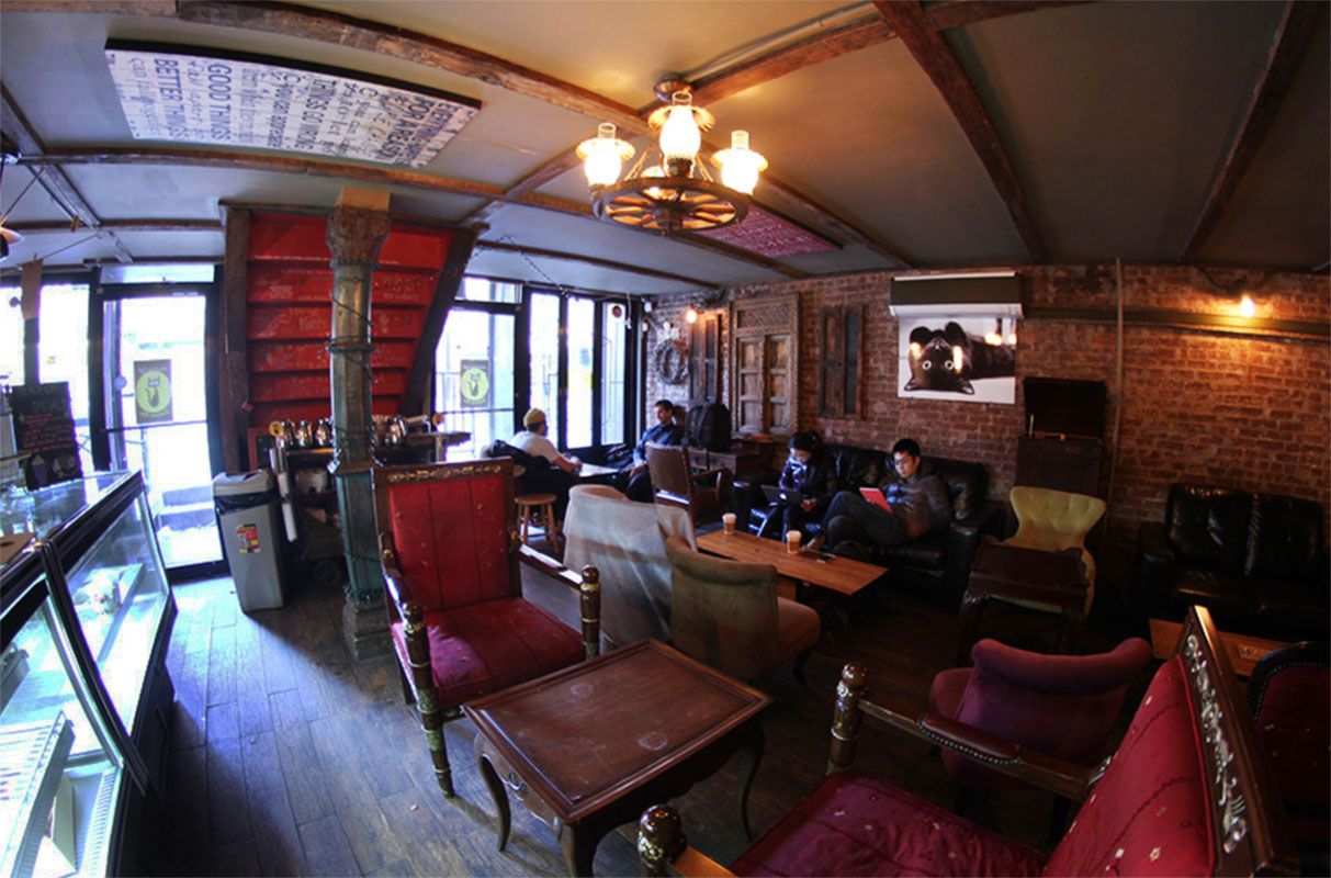Black Cat, a cozy coffee shop with red lounge furniture in LES
