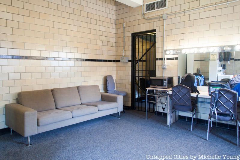Flushing Town Hall dressing room with furniture in a brick room that was a jail cell formerly.