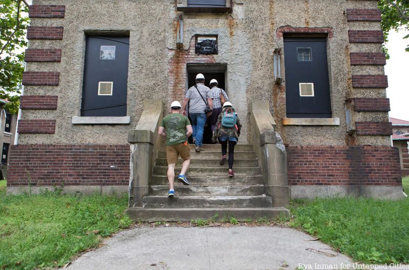 Tour guests walk into Ellis Island's abandoned hospital