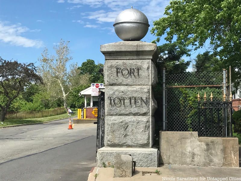 A stone fence entrance with a replica torpedo buoy on top