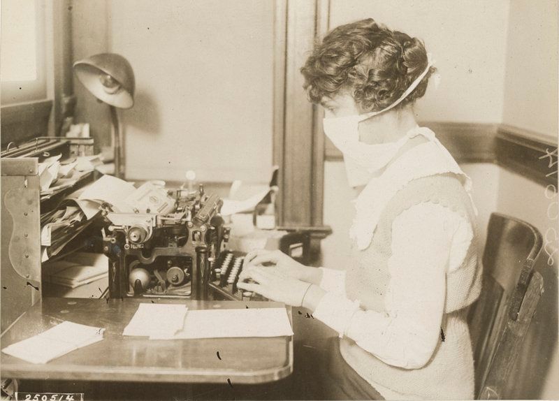 Typist wearing flu mask