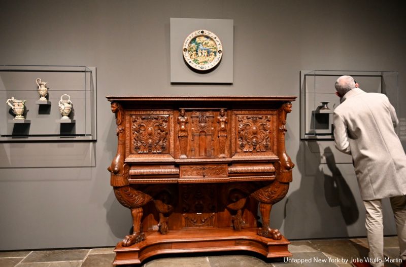 Frick Madison visitor examining French porcelains & cabinet