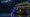 A Sapphire Doppler Karambit with a deep-blue swirled blade in front of a dark Kilowatt Case with yellow lightning trim.