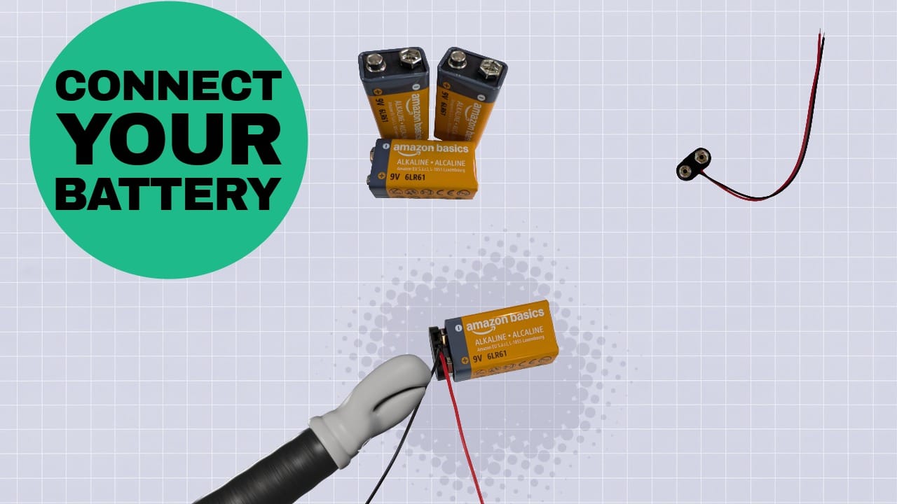 ELI's robot hand connecting the battery lead to a 9 volt battery