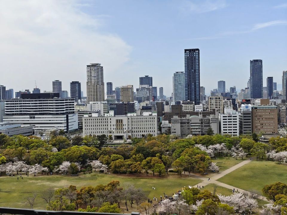 A photo taken from Osaka Castle, showing the castle grounds in the foreground and the city in the background