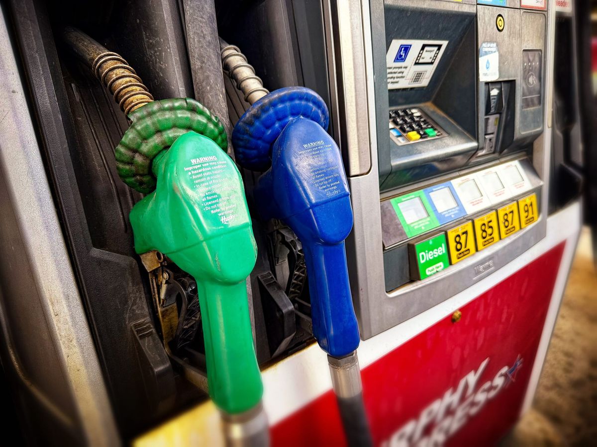 Green diesel and blue gasoline pump nozzles at a U.S. gas station