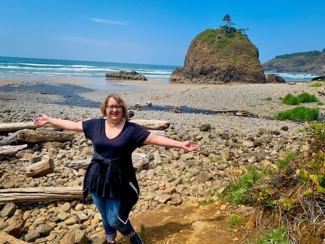 A picture of me on a rocky beach with my arms spread wide open
