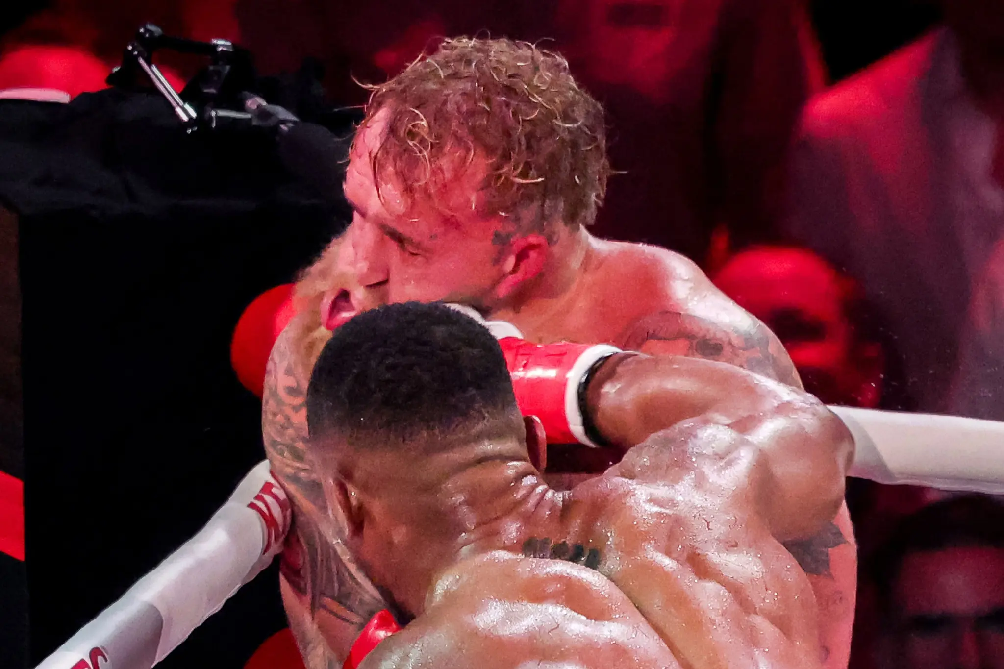 Jake Paul absorbs a punch from his opponent during a professional boxing match.