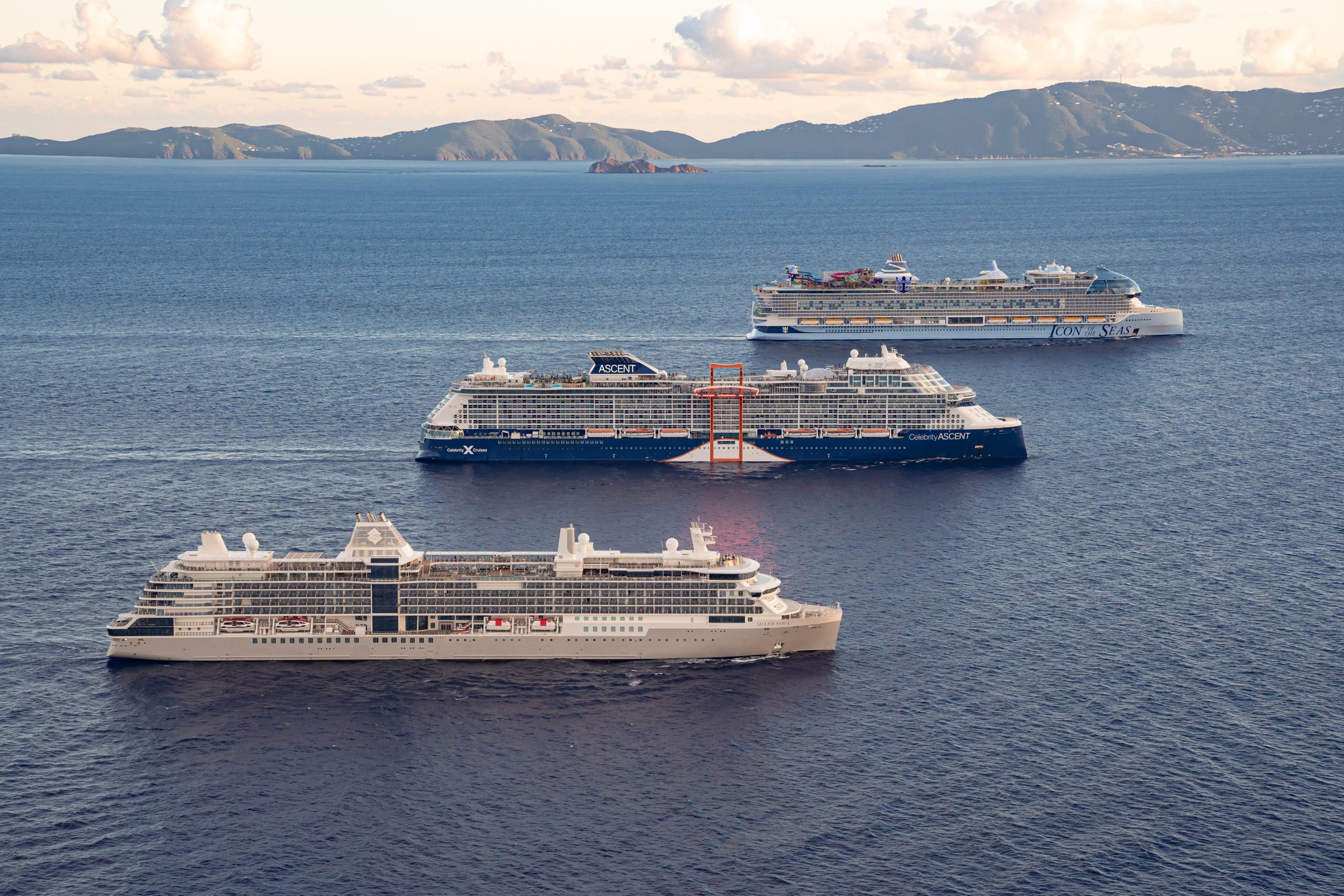 Multiple large cruise ships sailing in formation on open sea
