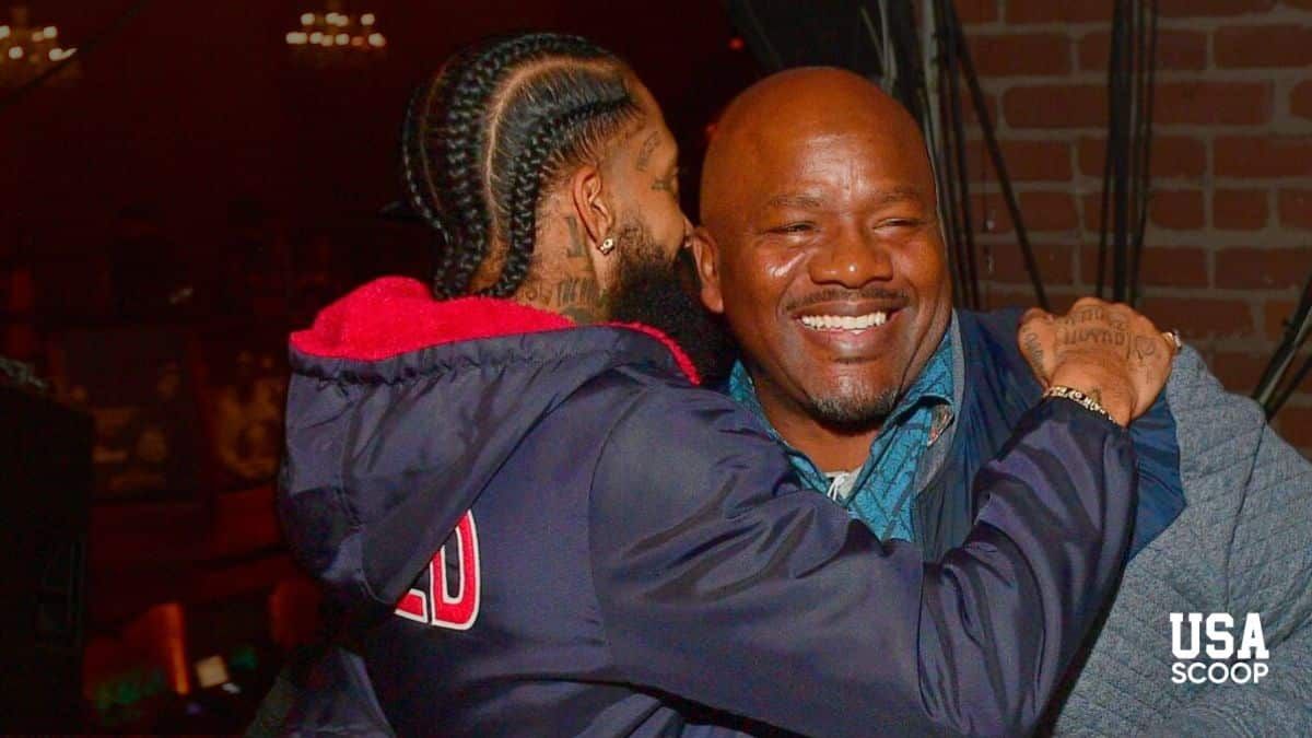 Big U smiling and embracing a friend in a warm moment before reports of his son’s death shocked the hip-hop community