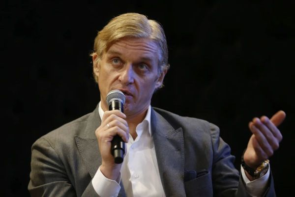 Oleg Tinkov speaking into a microphone during a public appearance