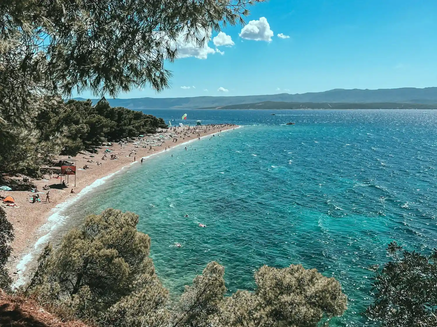 People sunbathing and swimming at Golden Horn Beach, Brač, Croatia.