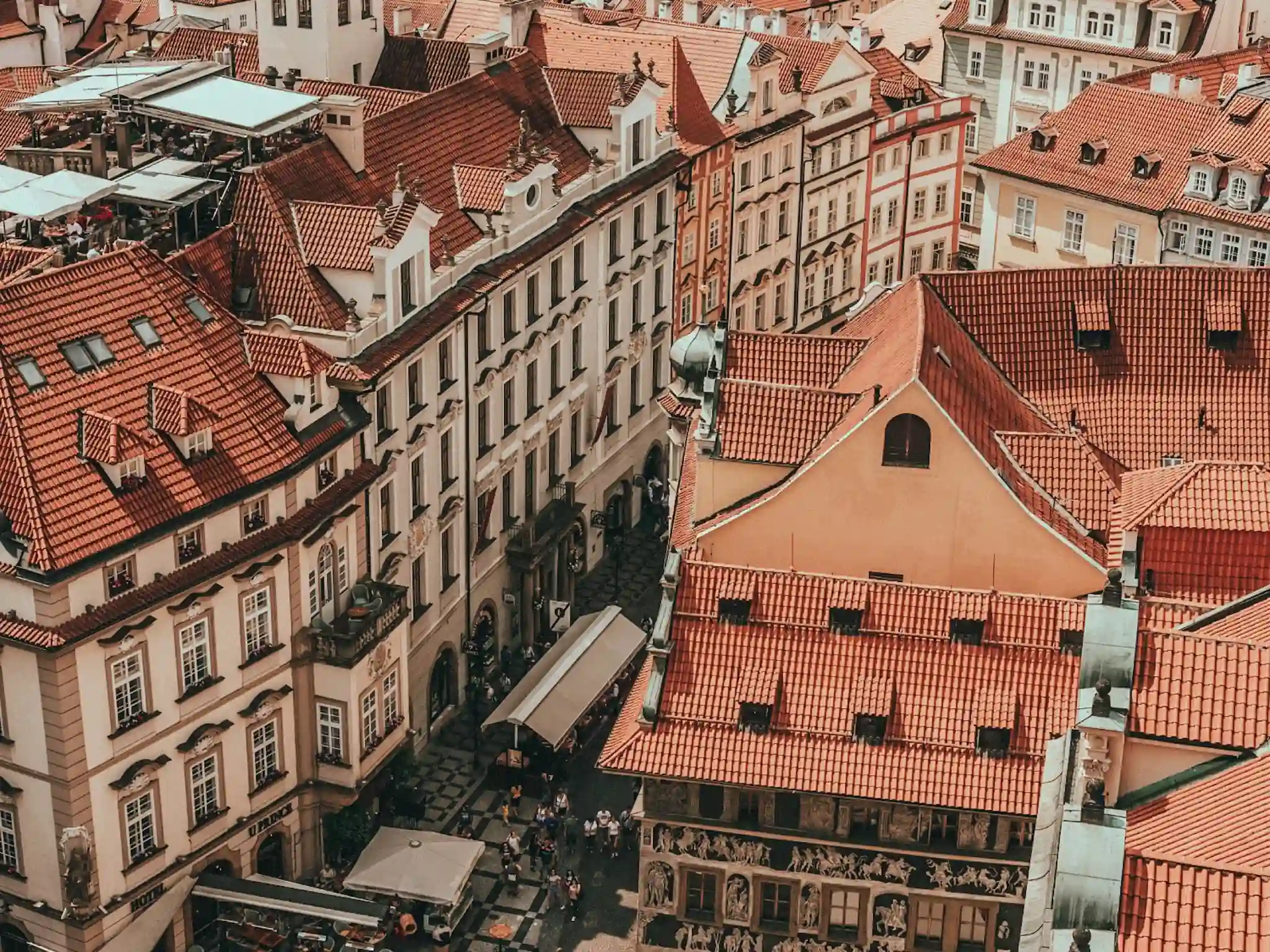 Aerial view of rooftops and people on streets in Prague Old Town.