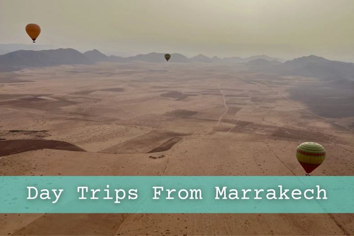 Picture taken from a hot Air Balloon ride in Northern Marrakech with surrounding landscape and mountains and three hot air balloons in the distance.