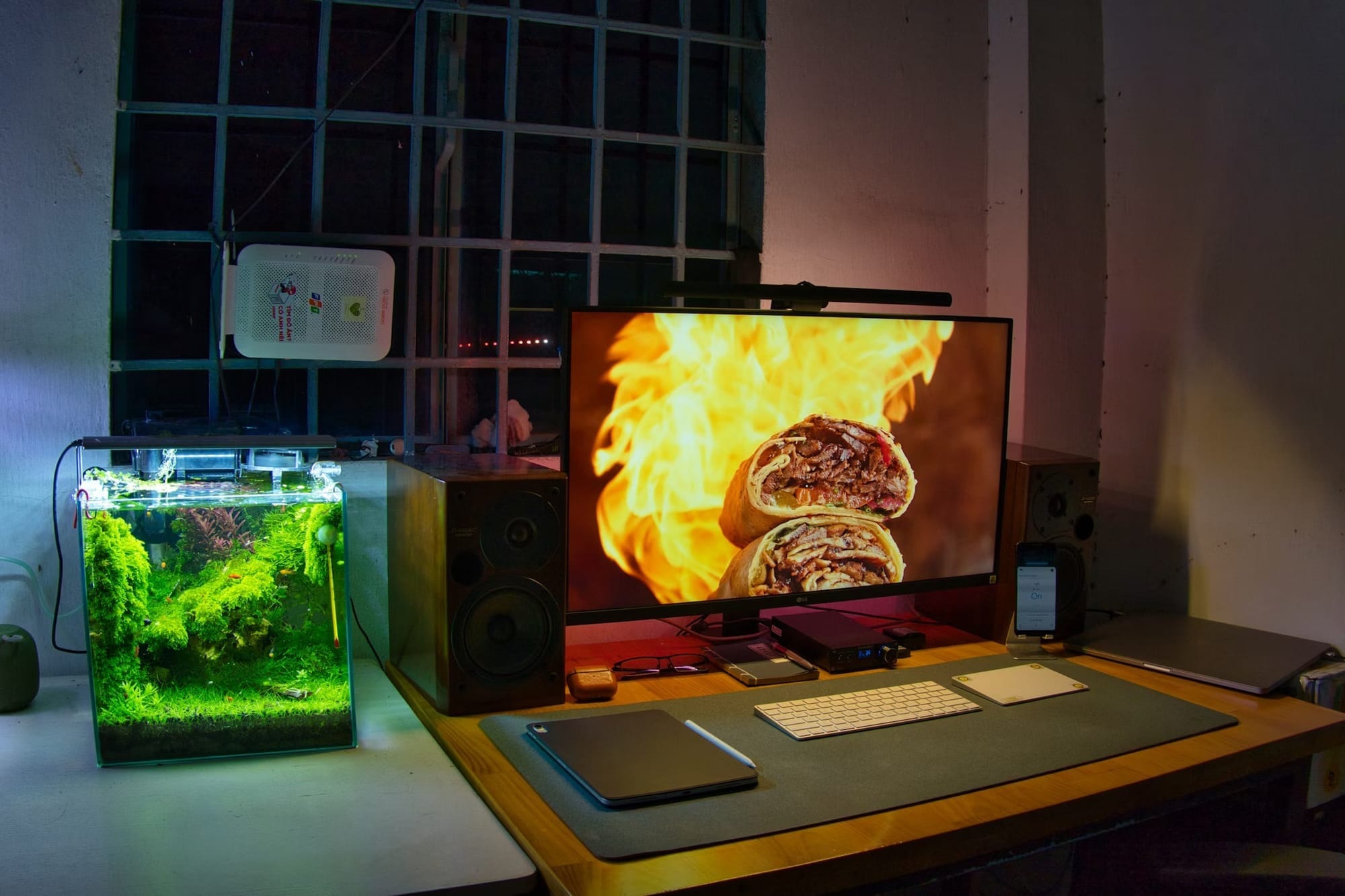 A home office with a monitor displaying two lunch wraps in front of a fire.
