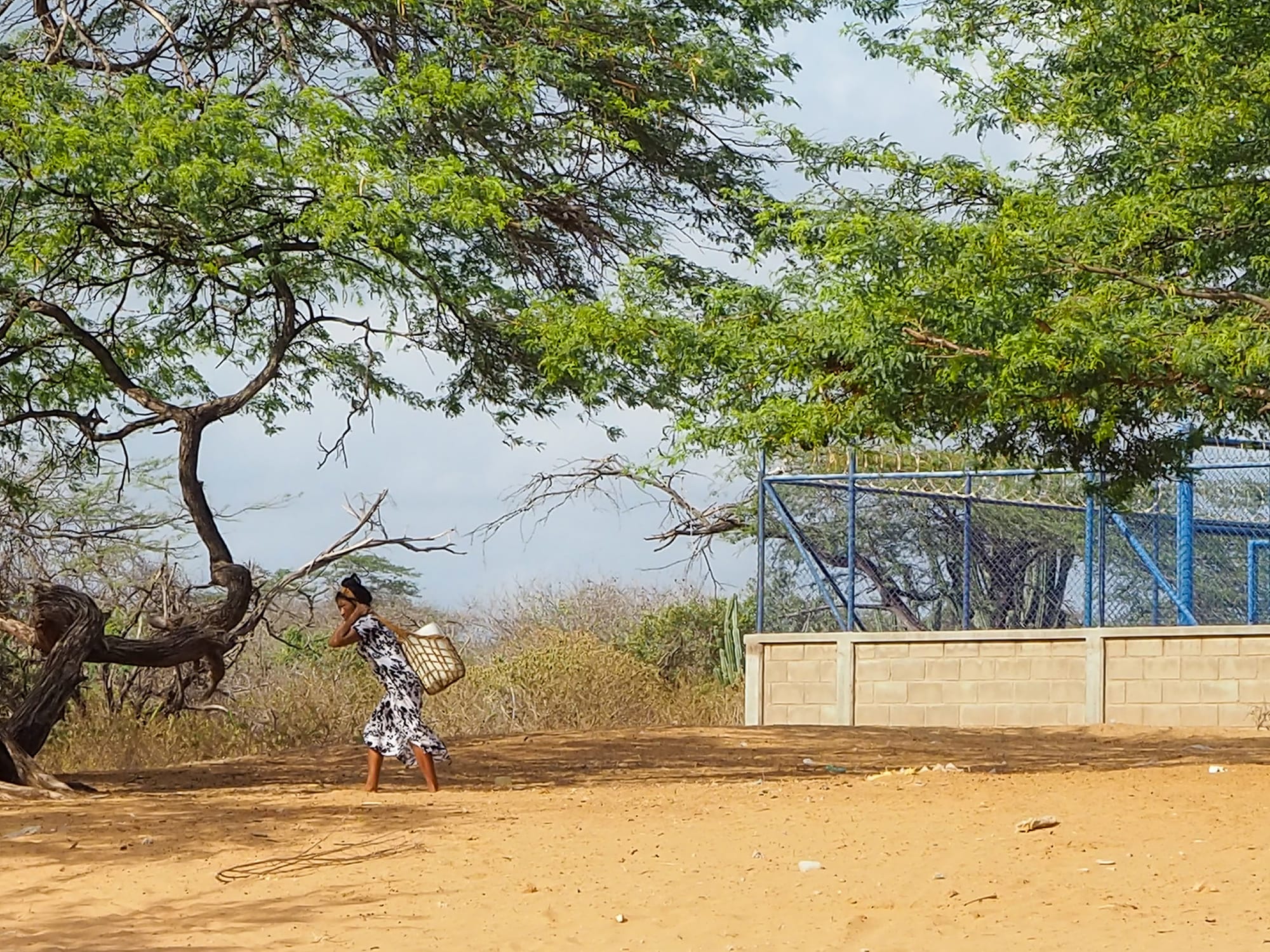 Mulher Wayuu carrega um galão de água