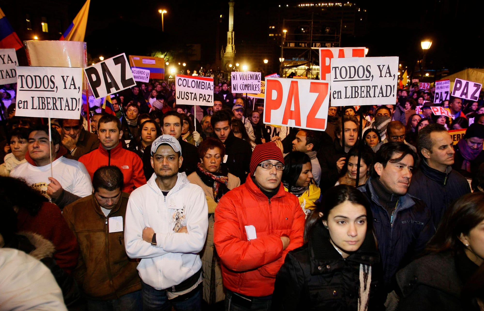 Manifestantes com cartazes à noite