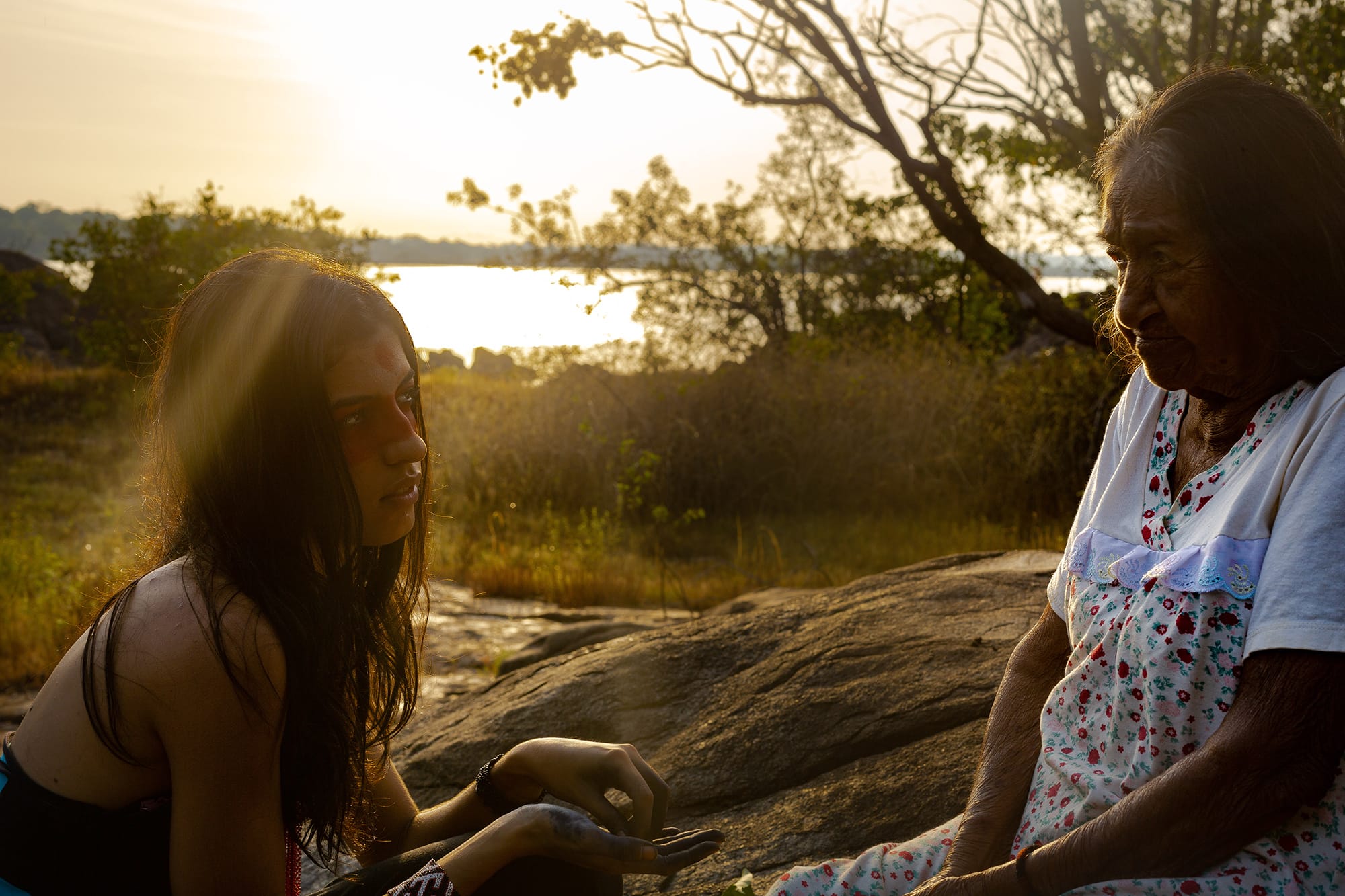 Lorena y Odete Kuruaya en la naturaleza con el sol poniéndose de fondo