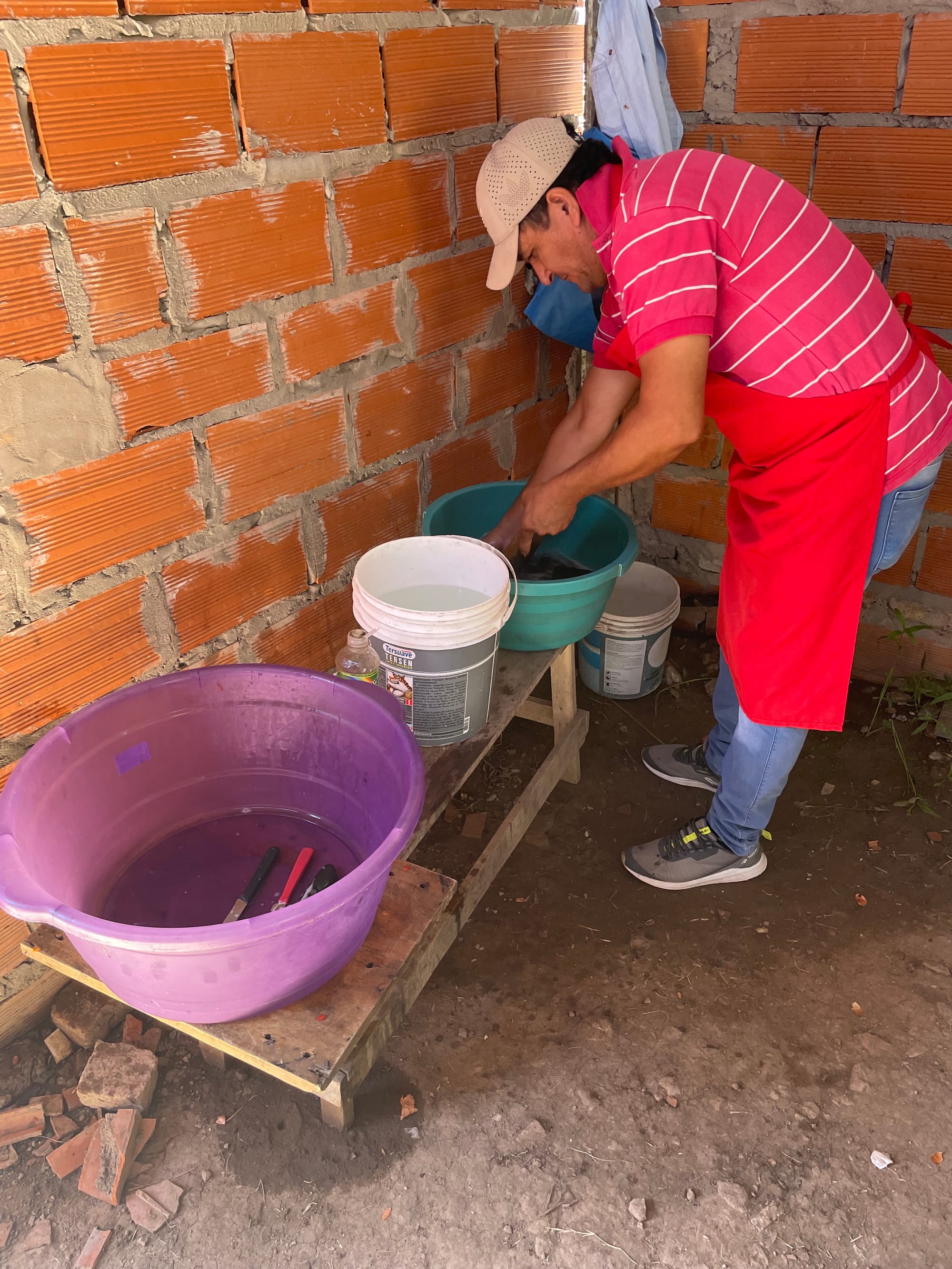 An activist of the Polo Obrero washes kitchen utensils in buckets at the Nueva Unión pot in the Villa Unión seizure