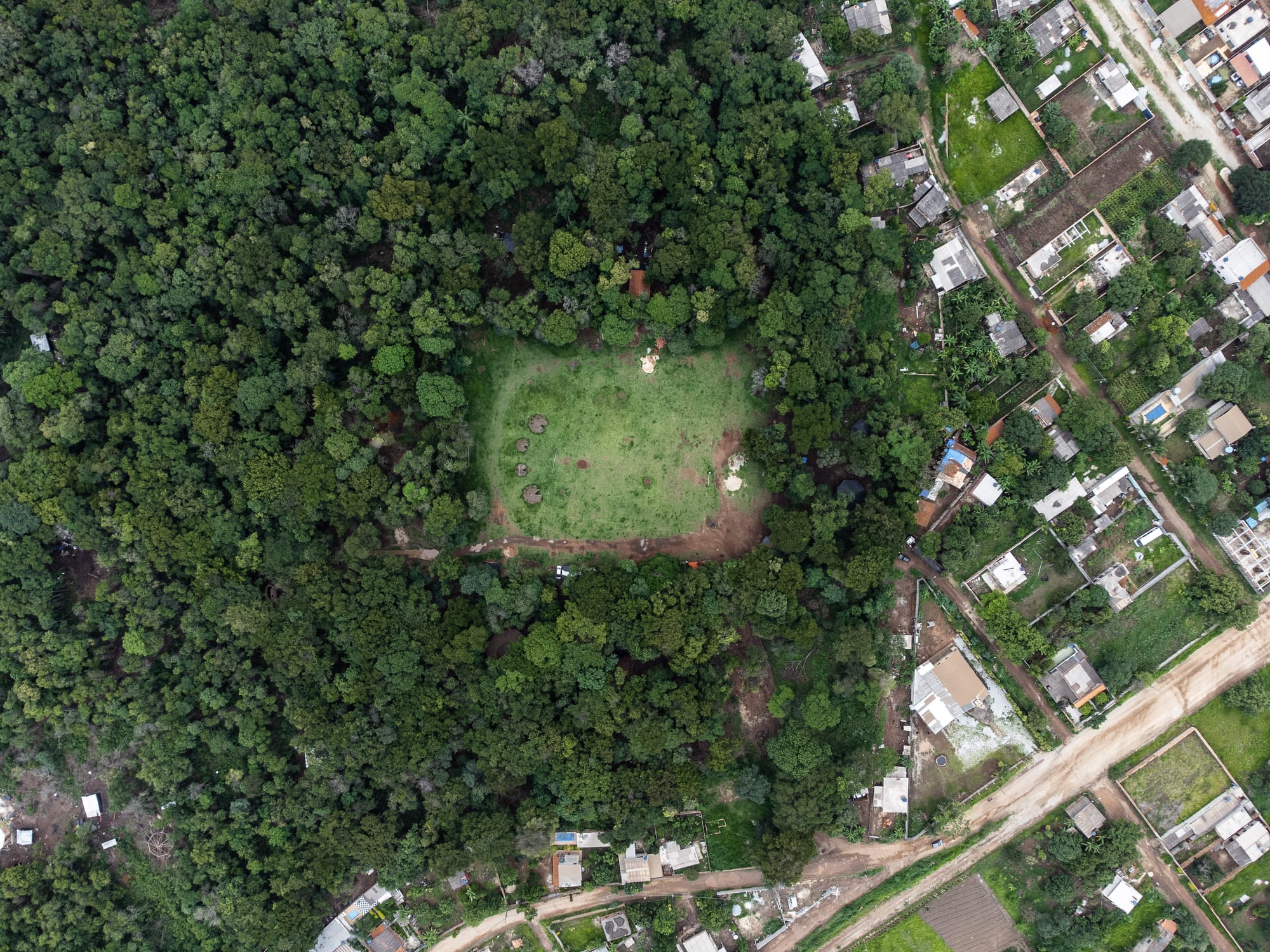 Vista de cima da comunidade cercada pelo verde da reserva florestal na divisa com o bairro