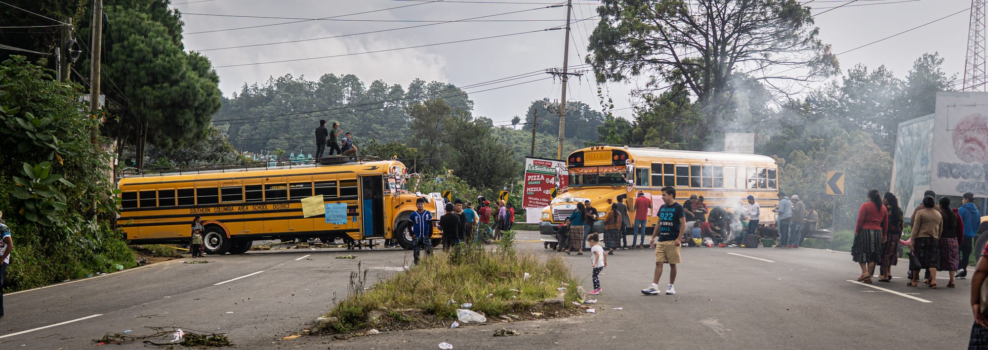 Manifestantes bloqueiam a estrada com caminhões escolares na Guatemala durante os protestos de outubro de 2023