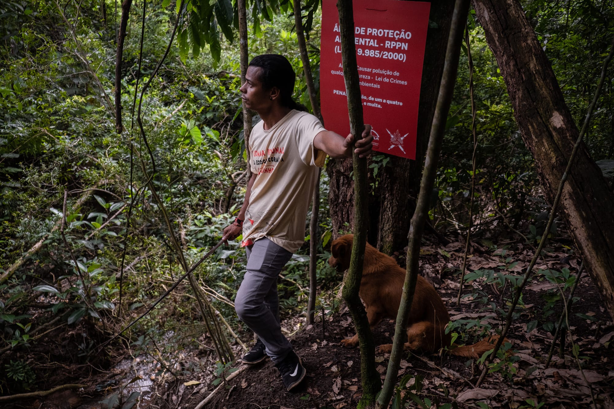 Hayó Pataxó posa ao lado de uma placa
