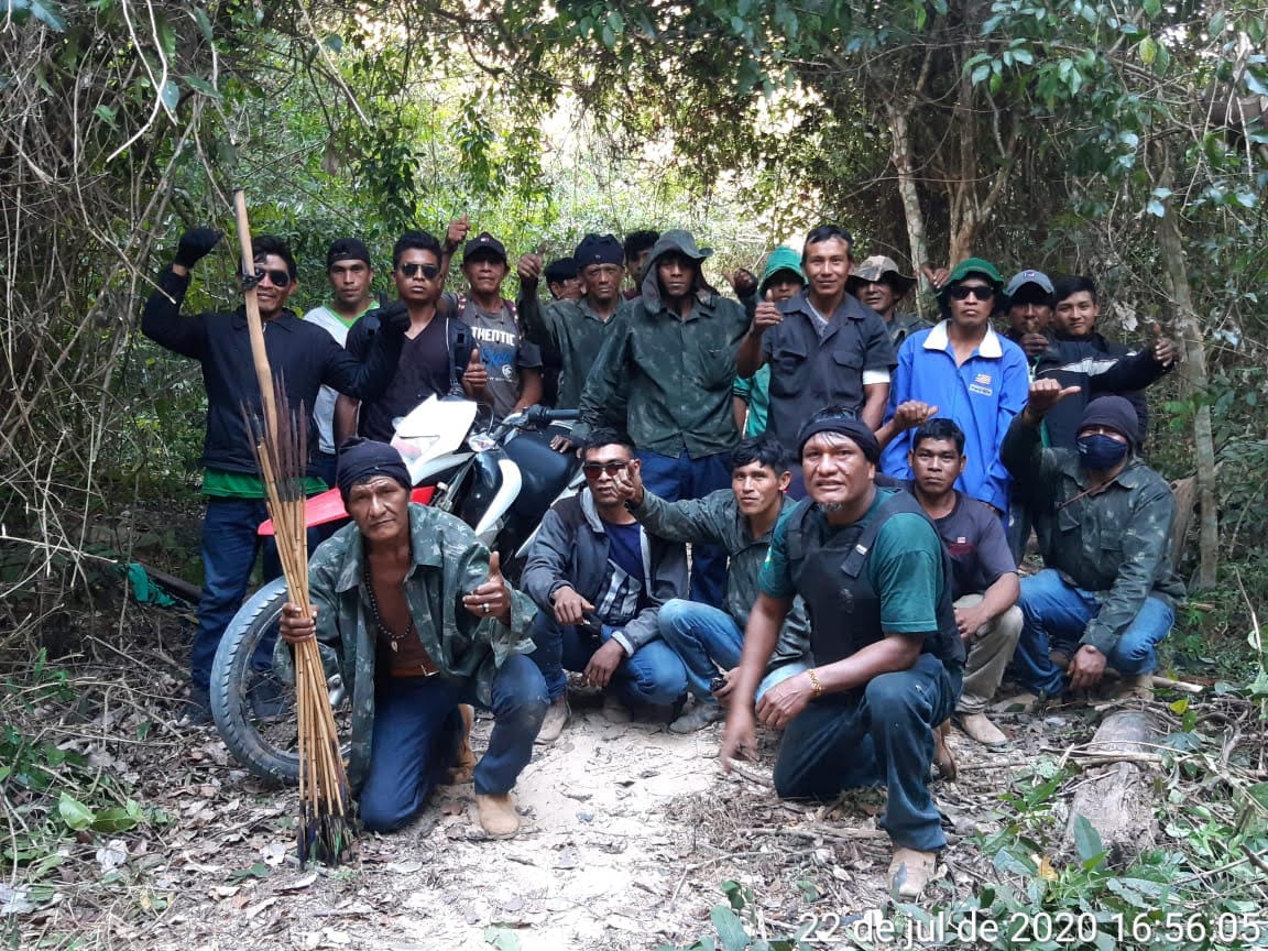 Olimpio Guajajara, agachado, usando un chaleco antibalas, al frente de uno de los equipos que hace rondas por la TI Arariboia. Los indígenas usan machetes y arco y flecha para defenderse de un eventual ataque de los madereros