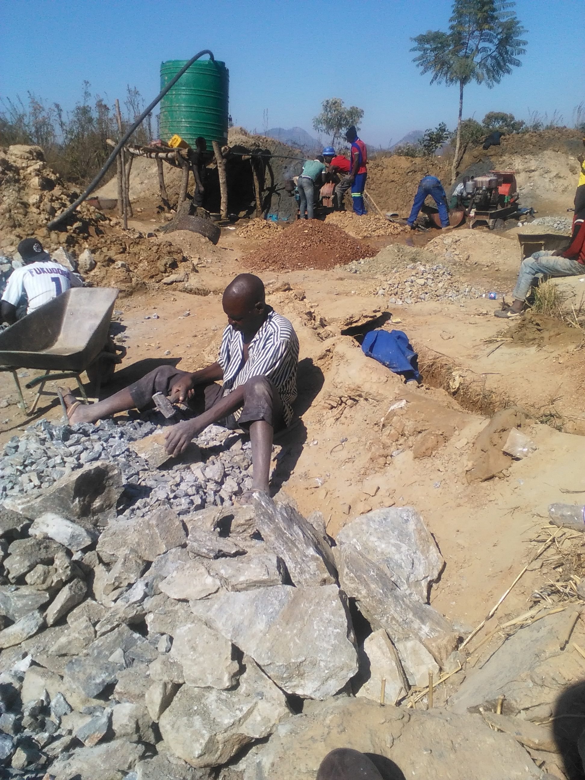 Men crush Ore blocks for the hammermill.jpg