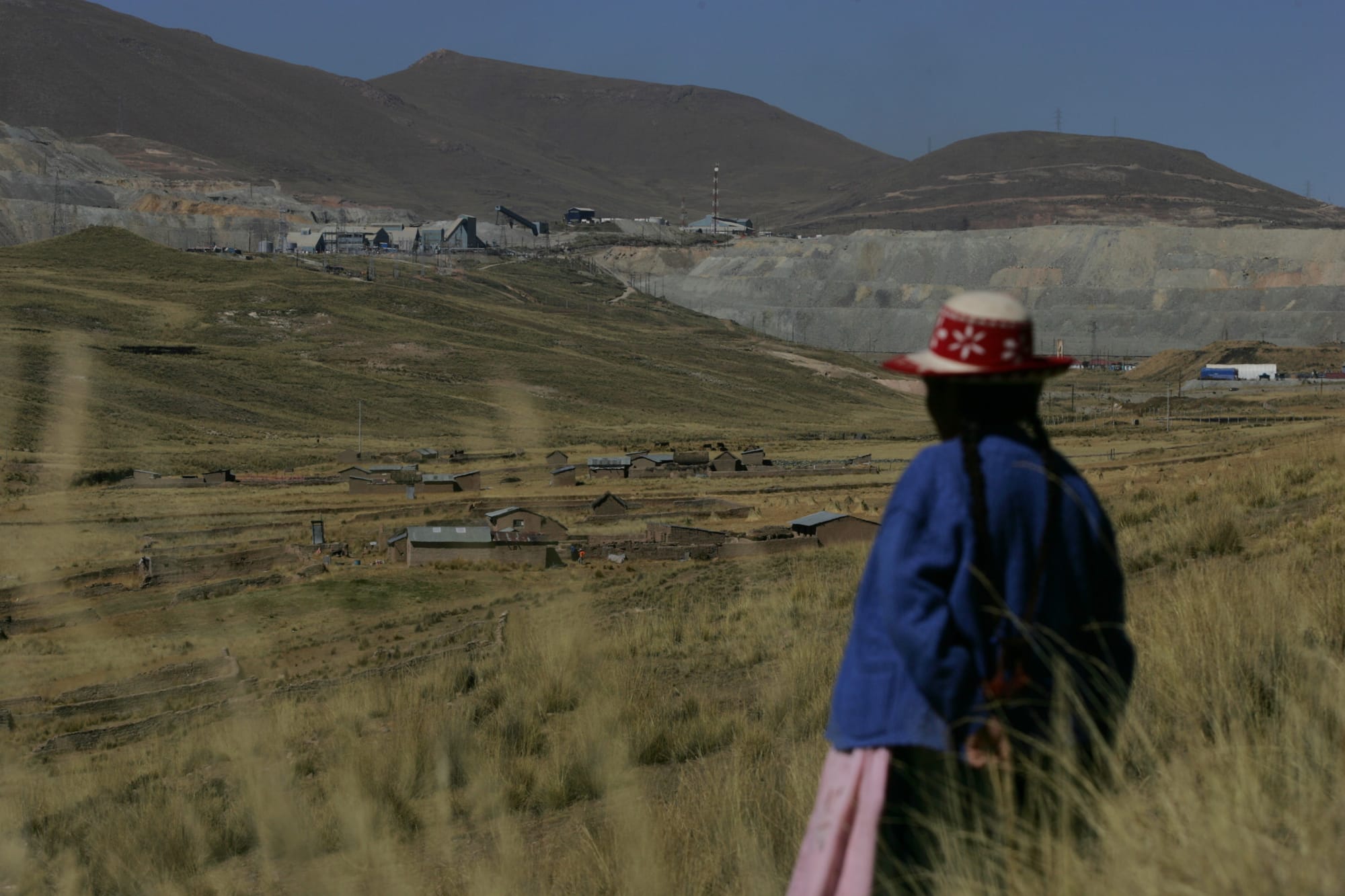 Mulher indígena de costas olhando para a mina