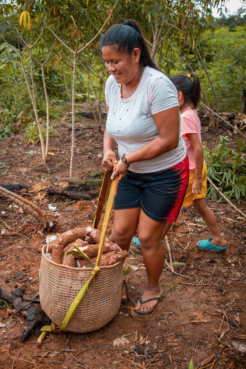 Nancy segurando um saco de mandioca