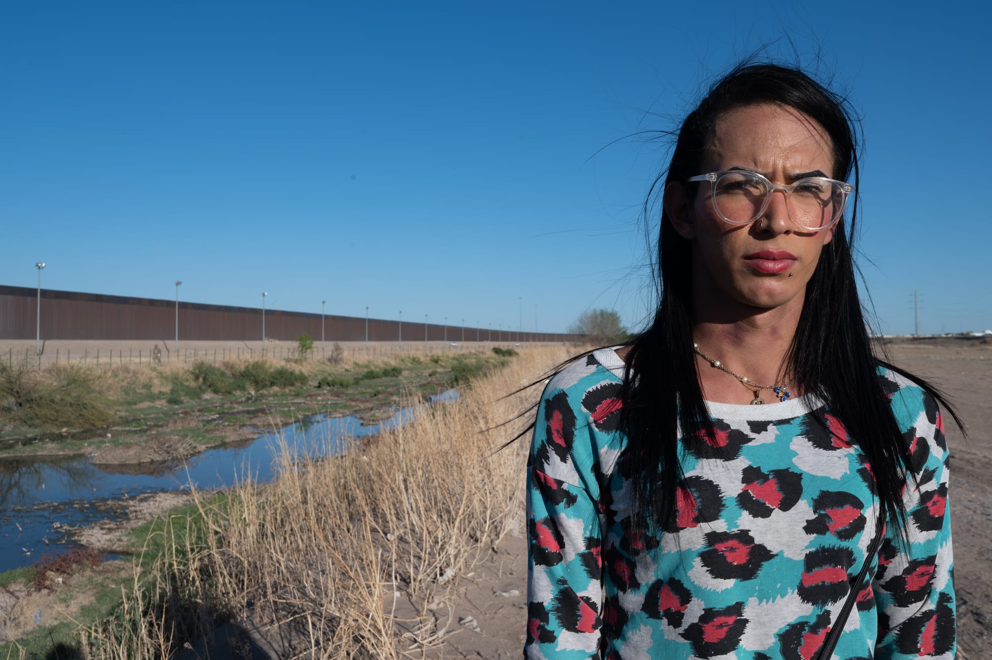 Rebeca Camacho, imigrante venezuelana, posa frente ao muro que a separa dos Estados Unidos