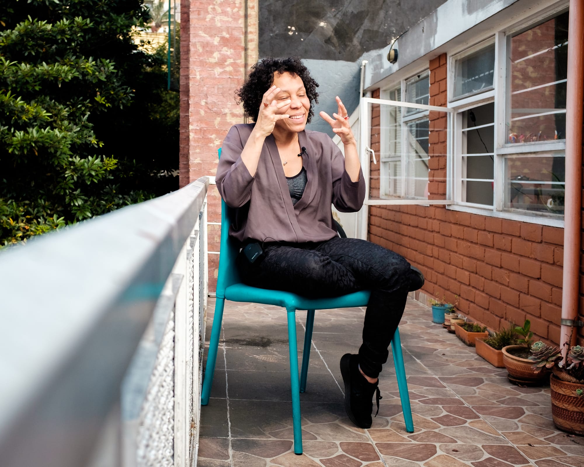 Hilse gesticula sentada em cadeira azul