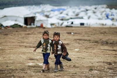 Syrian boys, whose family fled their home in Idlib, walk to their tent, at a camp for displaced Syrians, in the village of Atmeh, Syria, Monday, Dec. 10, 2012_0_1.jpg
