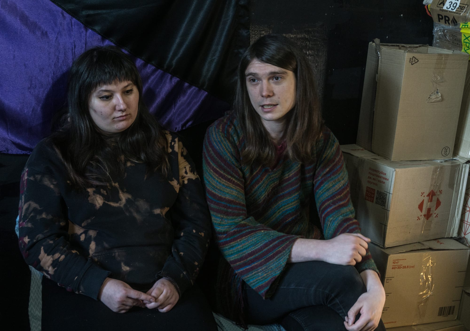 Yulia Lutyi-Moroz and Alisa Shampanska from FemSolution, next to the boxes full of menstrual products their organisation distributes