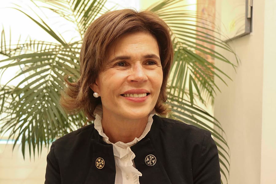 Cristiana Chamorro sorri em frente a uma planta