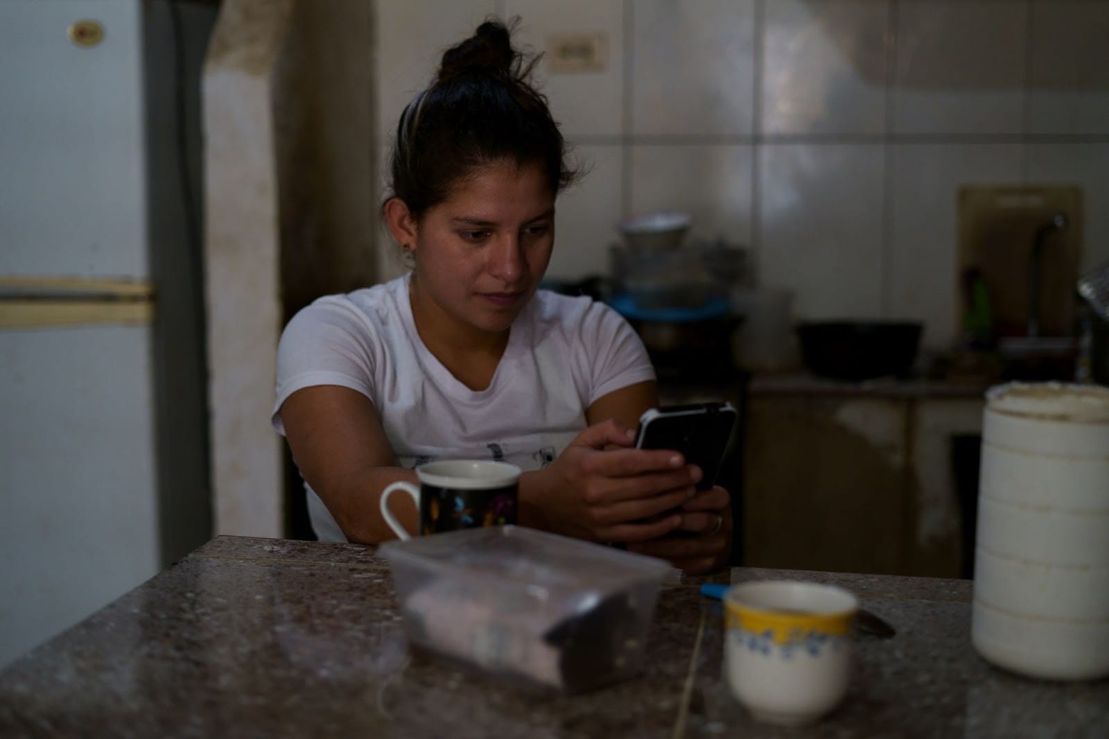 María Gabriela Valecillos revisa su teléfono luego de terminar su cuarentena por el COVID-19 en Caracas, el 10 de marzo de 2021. Foto: Yadira Pérez