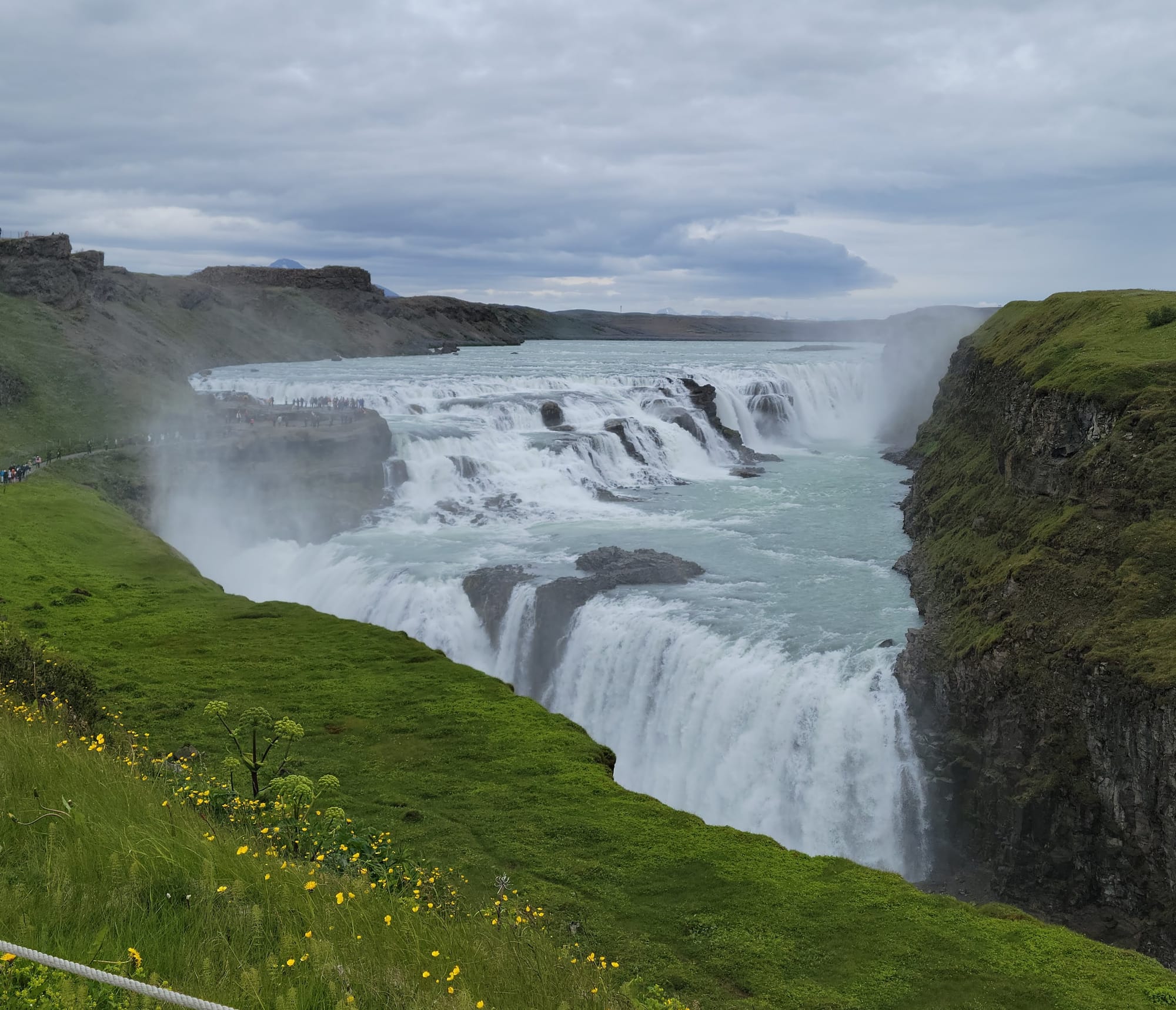 A photo of an enormous waterfall shadowed by green mossy cliffs