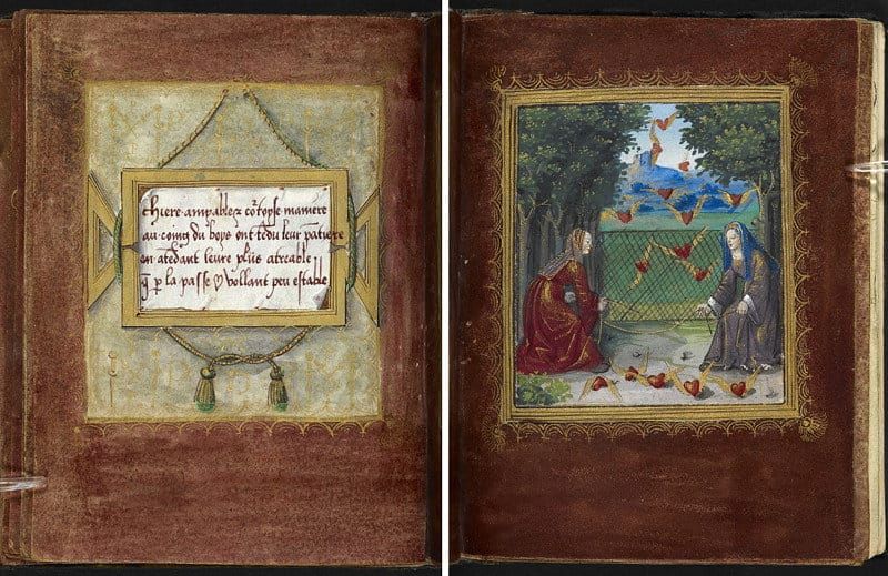 A photograph of an open book. On the left side is an illuminated paragraph of French calligraphy. On the right side is a framed painting of two women capturing winged hearts in a net.