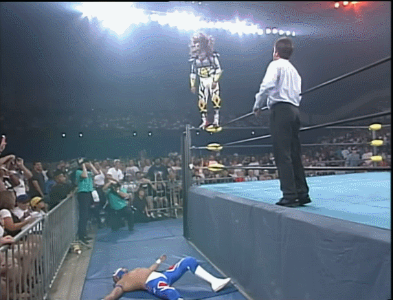 Psychosis hits a senton off the top rope to Rey on the floor