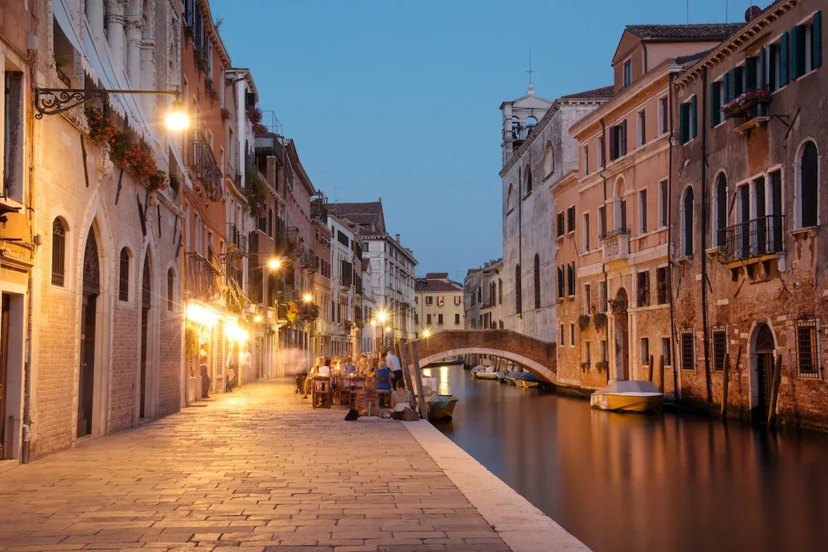 Evening canal scene in Cannaregio Venice with historic buildings and local restaurants