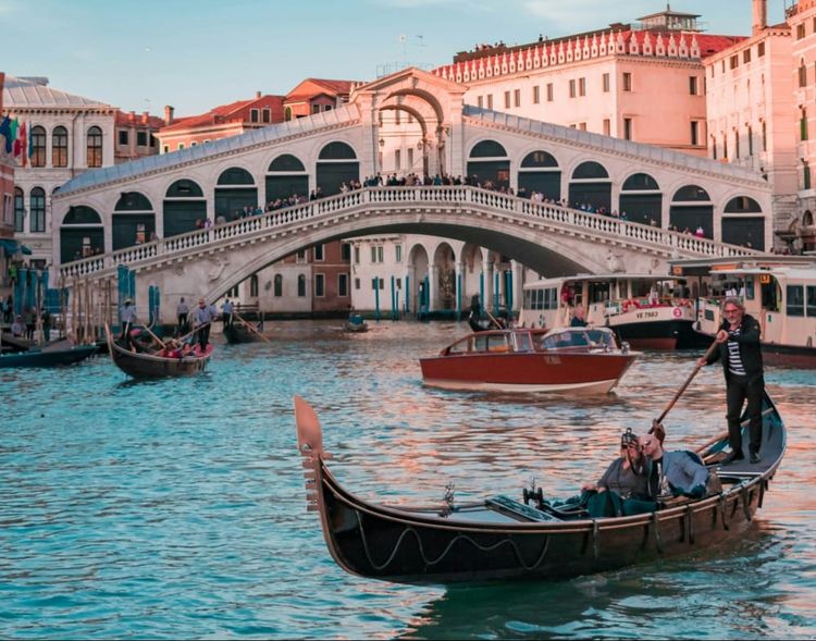 First-time visitors enjoying a gondola ride near Rialto Bridge in Venice