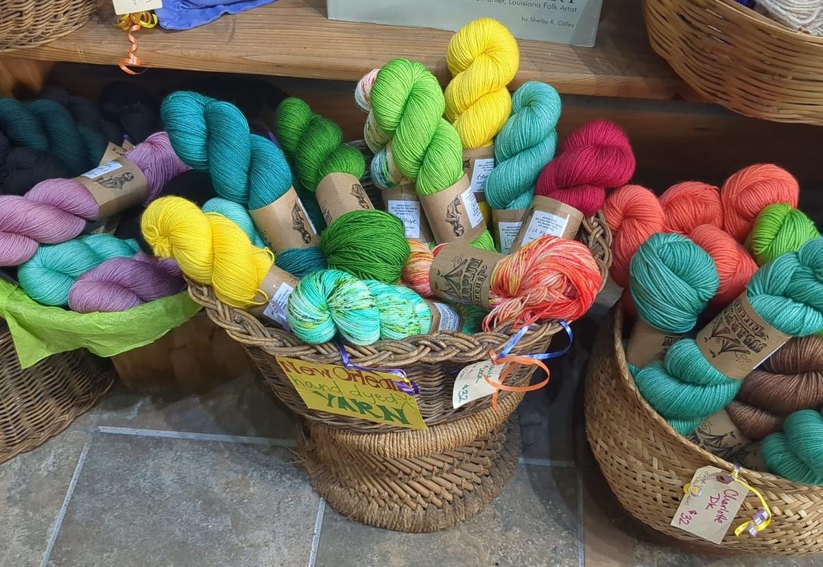 Colorful skeins of yarn in a basket labeled New Orleans hand dyed yarn.