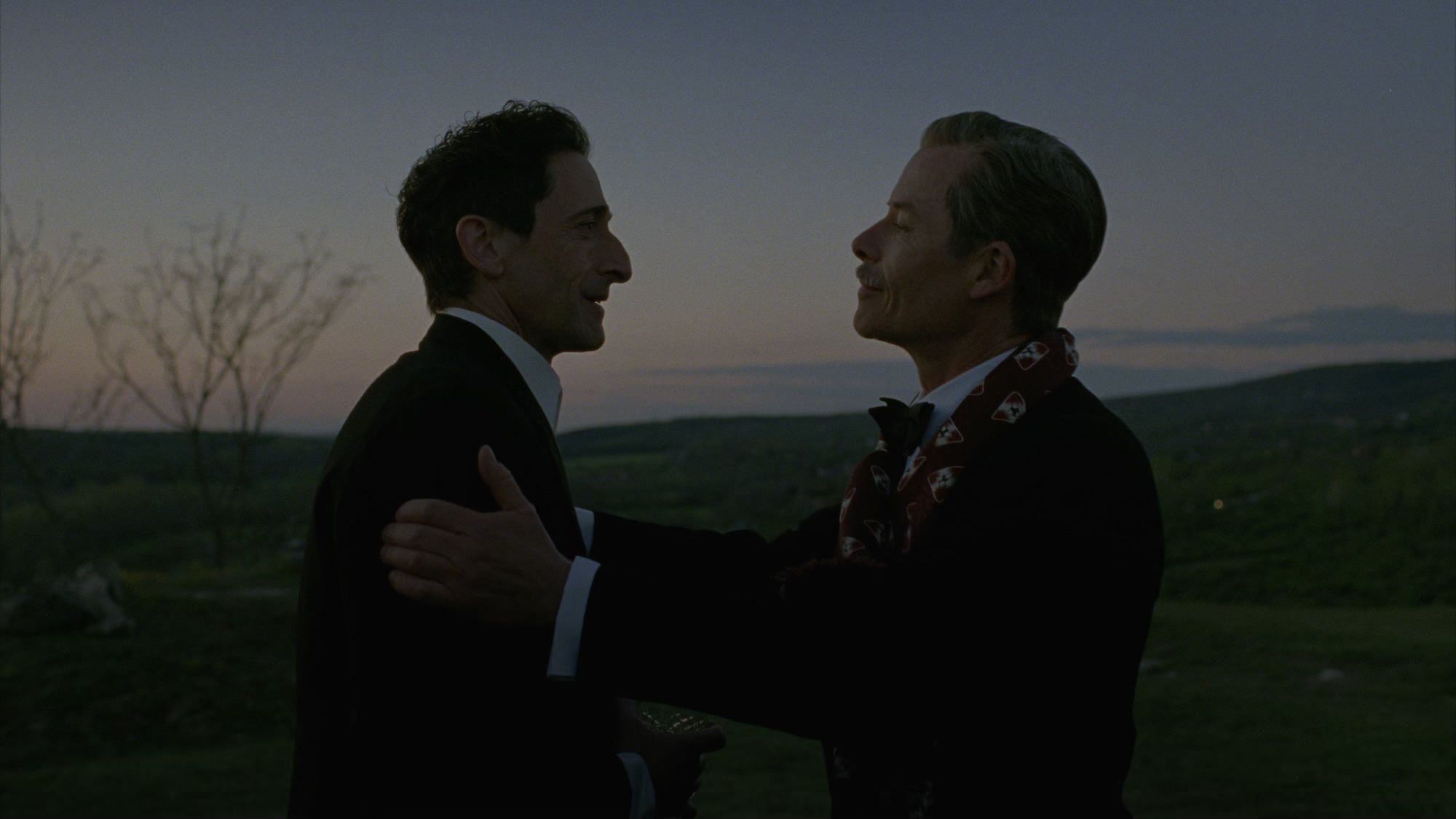 Adrien Brody as László Tóth and Guy Pearce as Harrison Lee Van Buren in The Brutalist