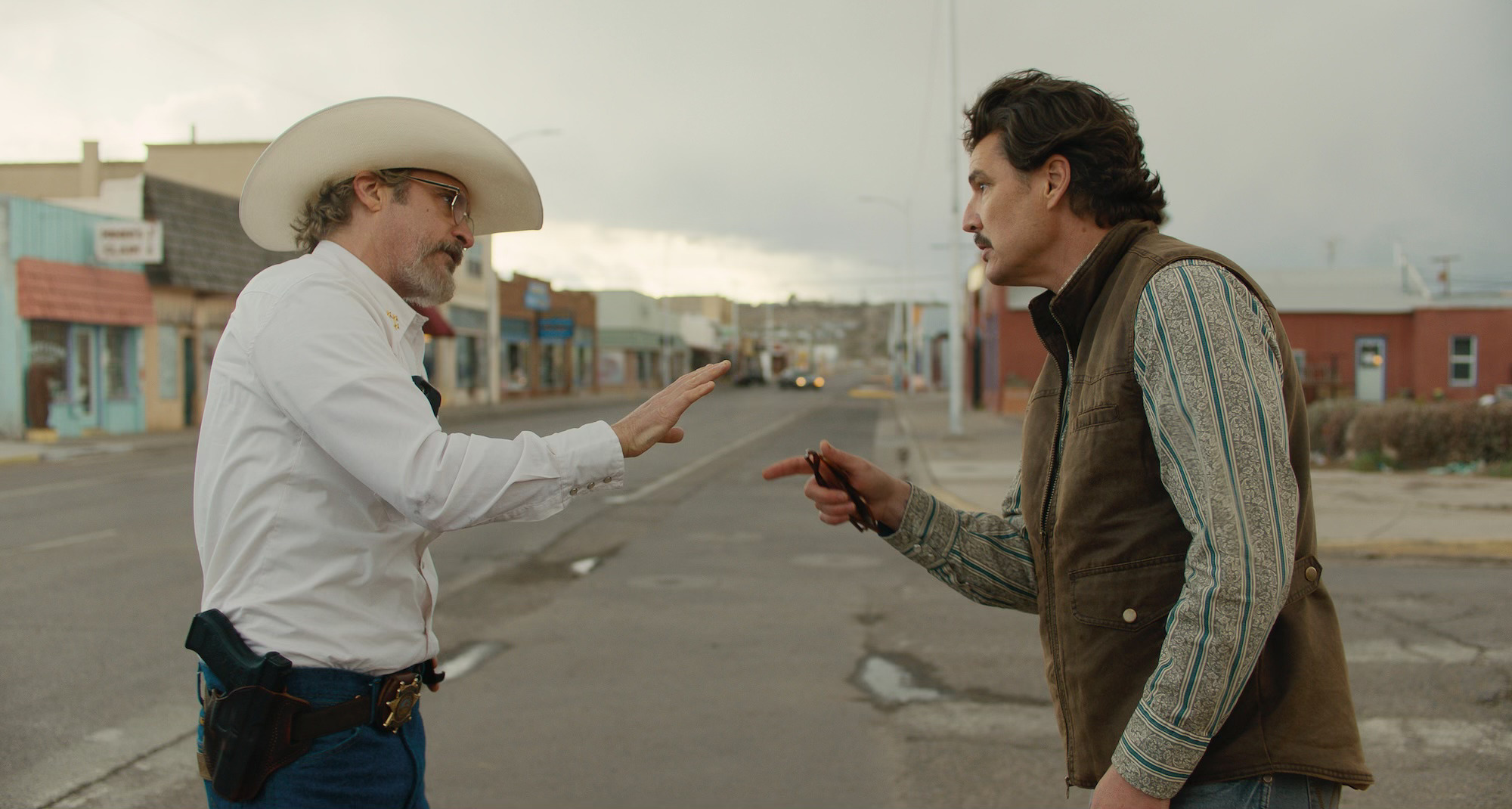 Joaquin Phoenix as Sheriff Joe Cross and Pedro Pascal as Mayor Ted Garcia in Eddington