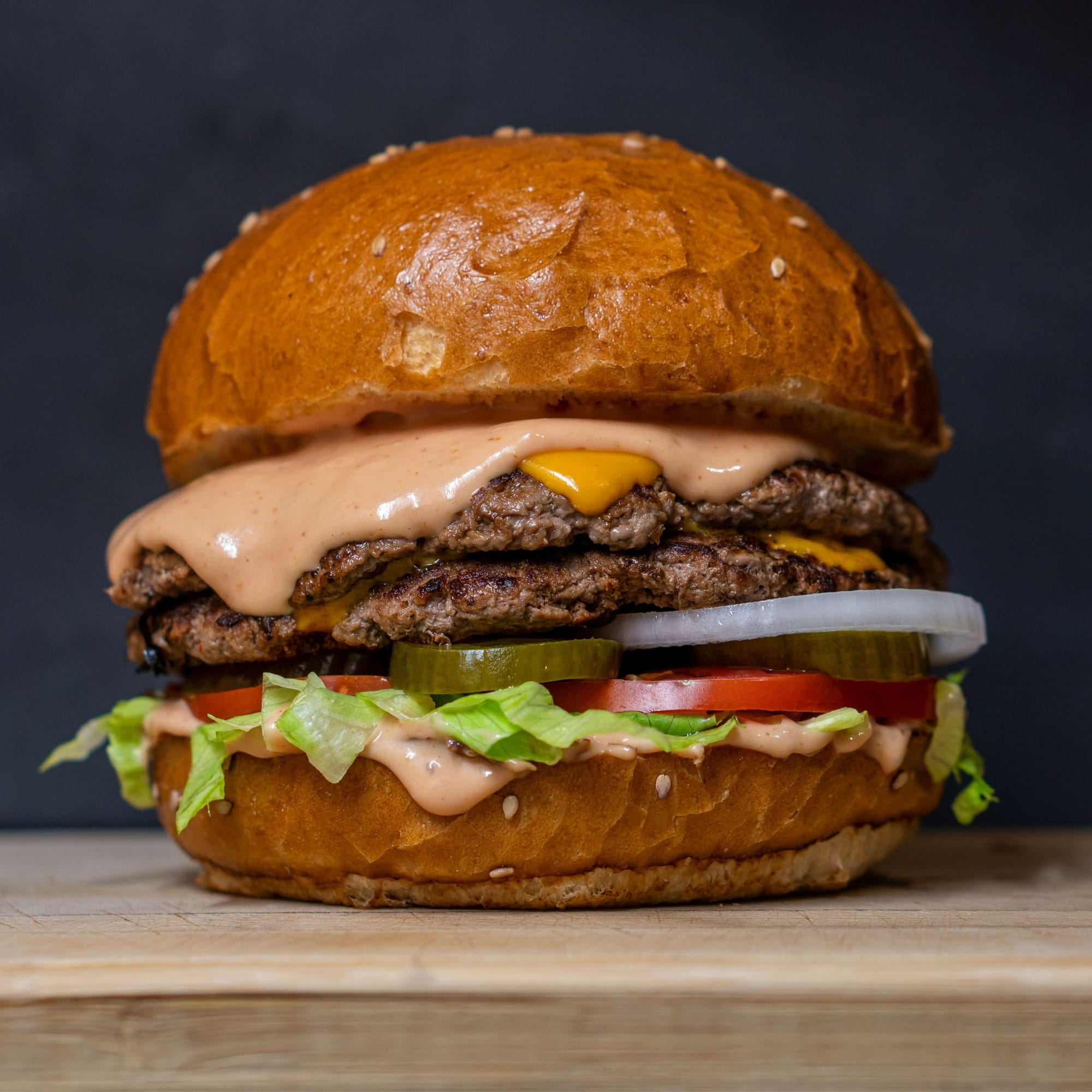 A burger layered with lettuce and tomato inside its bun