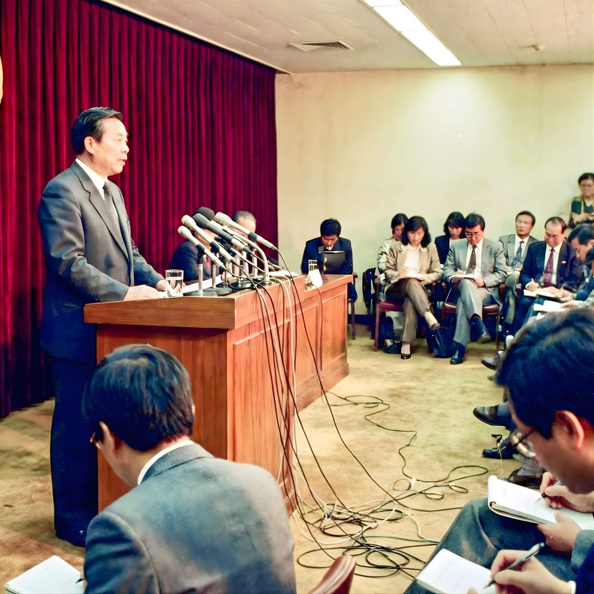 Government spokesperson addresses journalists at podium during official press briefing