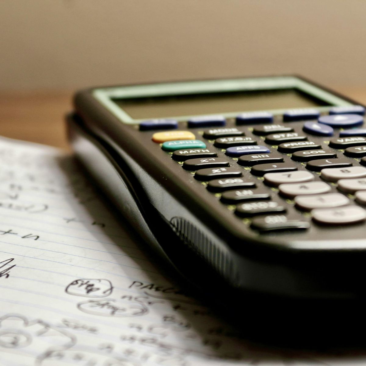 Scientific calculator resting on handwritten math notes and equations