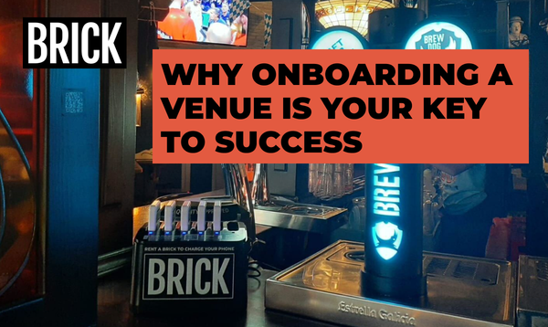 A 6 slot Brick power bank sharing station placed prominently on a bar
