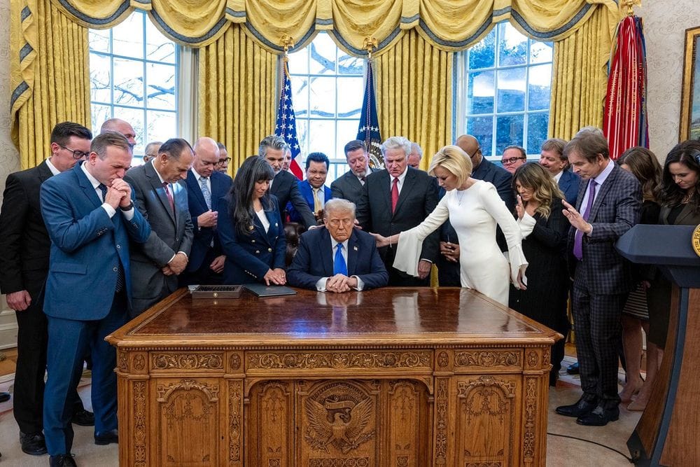 A bunch of christians lay hands on their golden calf of a president in the Oval Office and pray.