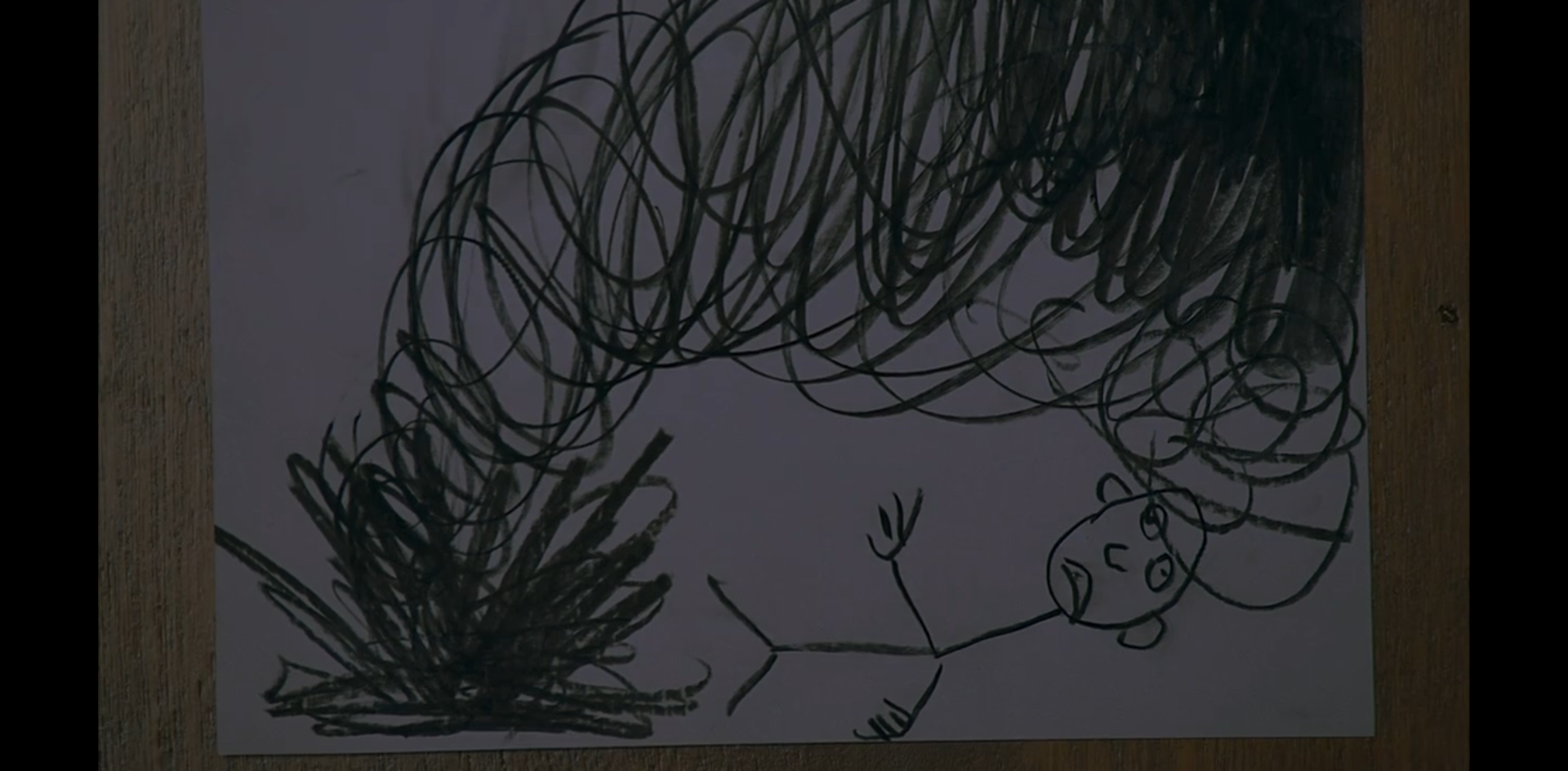 A child's drawing of a sick figure being attacked by a dark mass that explodes from the ground.